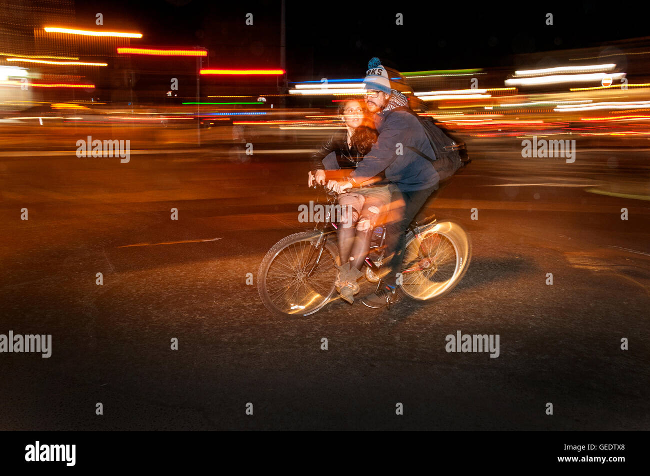 Coppia in bicicletta in tarda serata, Dublino, Irlanda Foto Stock