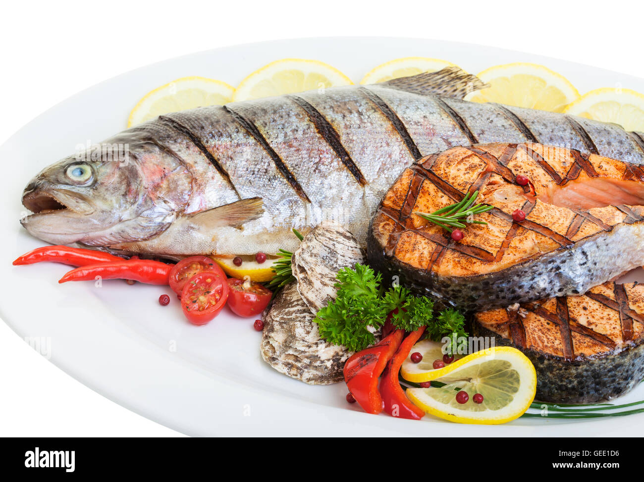 Close up grigliate di trote e salmoni bistecche con verdure e ostriche Foto Stock