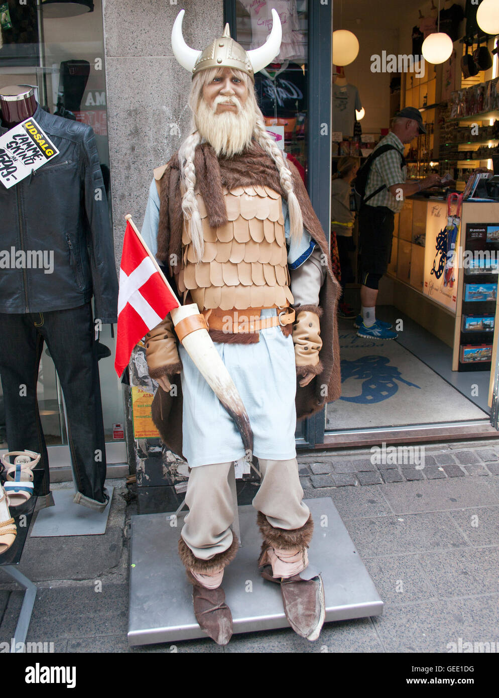 La stravagante statua vichinga si erge davanti a un negozio di souvenir a Copenaghen, Danimarca, accogliendo i visitatori con un tocco nordico. Foto Stock