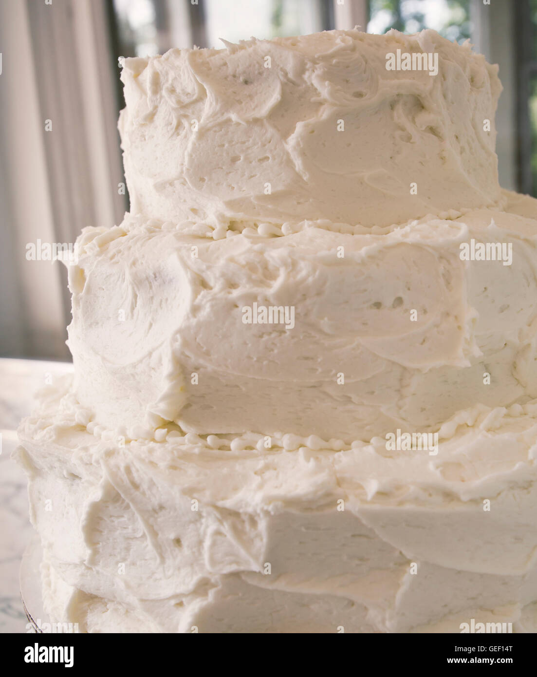 Bianco satinato bianco torta di nozze con tre livelli. Foto Stock