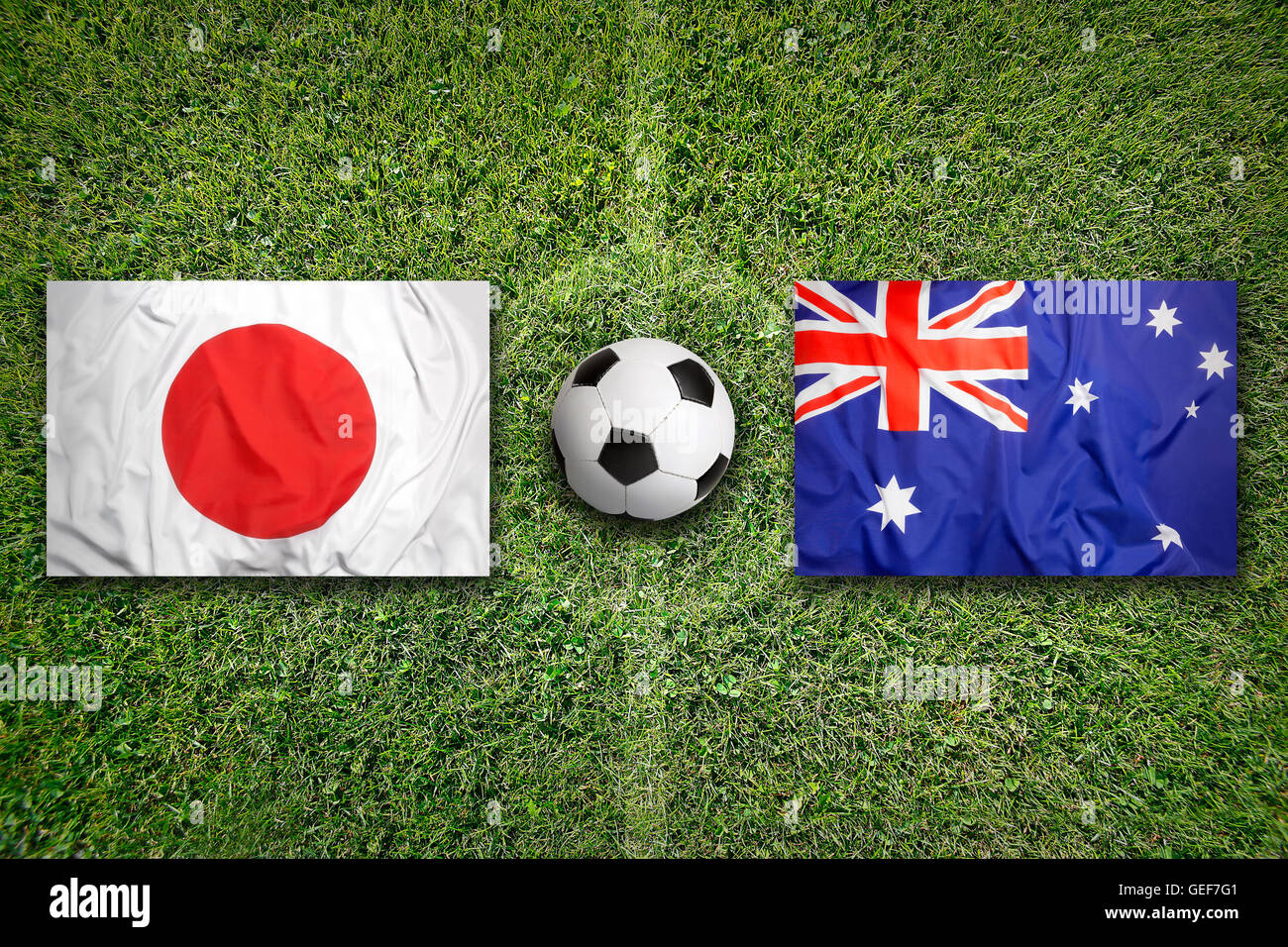 Giappone vs. Australia bandiere sul verde del campo di calcio Foto Stock