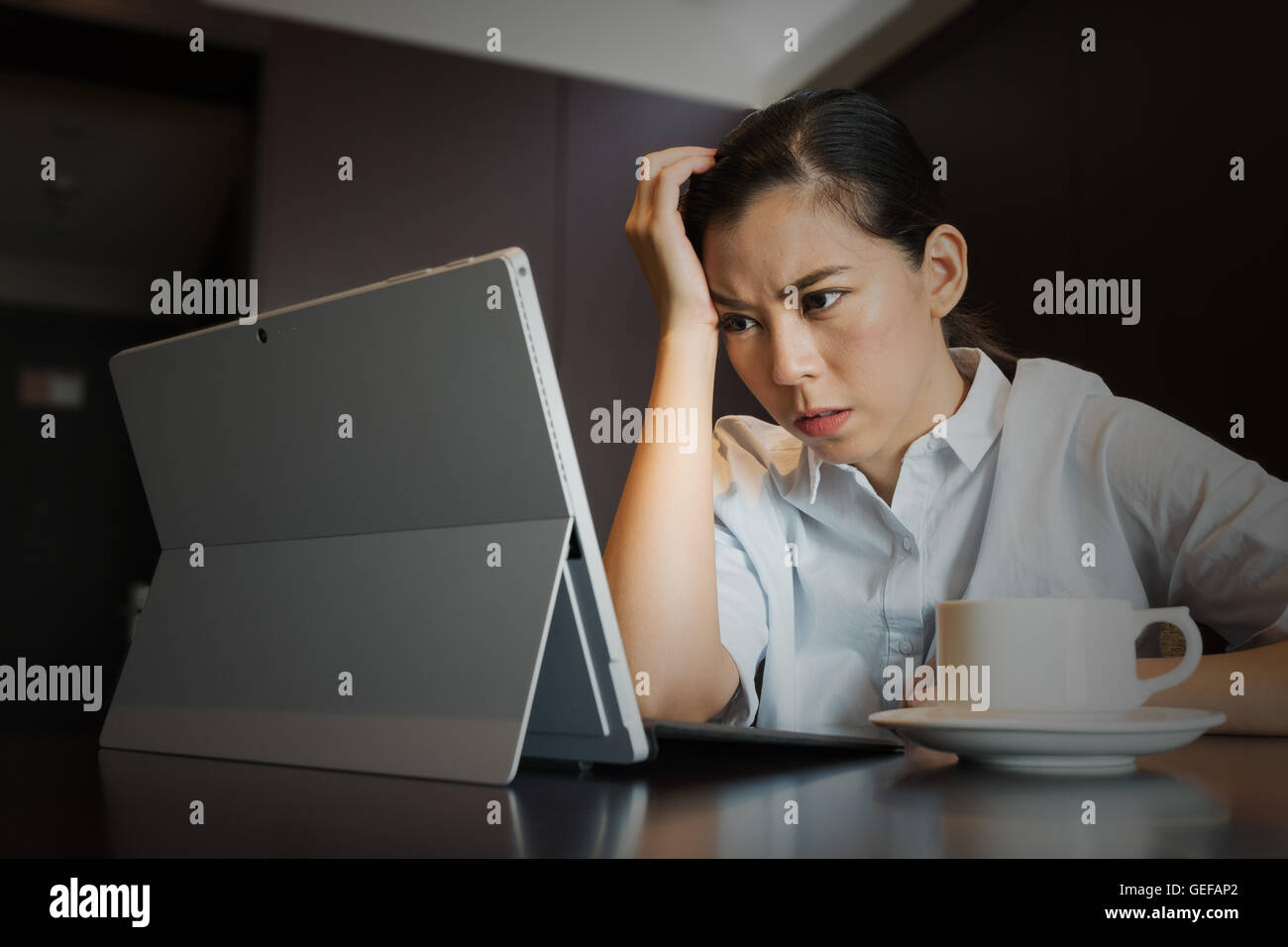 Frustrati imprenditrice avente mal di testa tenere testa a mano sconvolto mentre si lavora, seduta utilizzando tablet portatile, guasto di lavoro Foto Stock