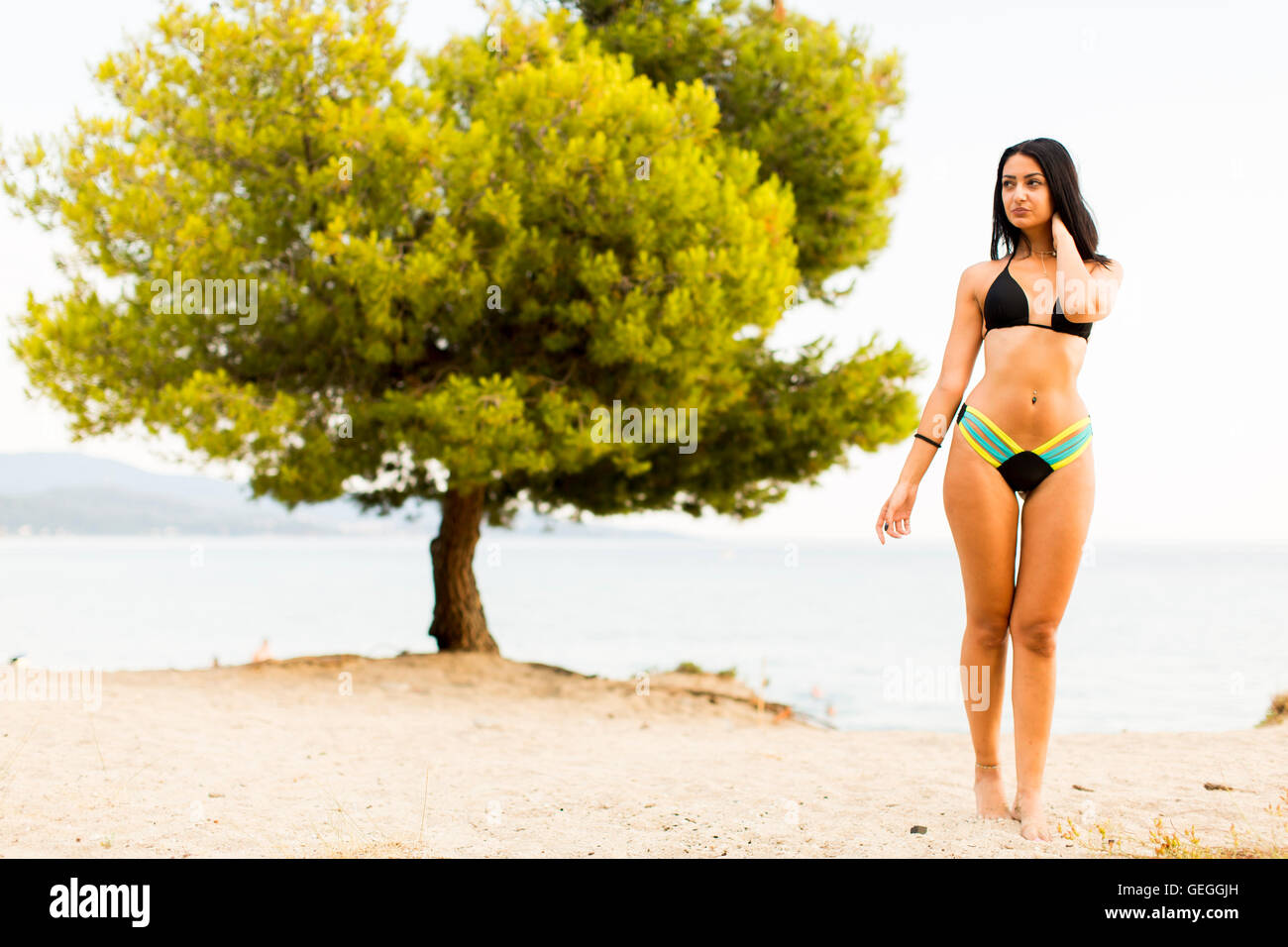 Bella giovane donna sulla spiaggia sabbiosa di estate Foto Stock