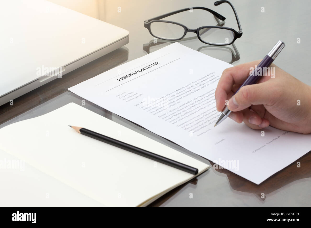 Lettera di dimissioni di informazioni con penna, matita e bicchieri. Foto Stock