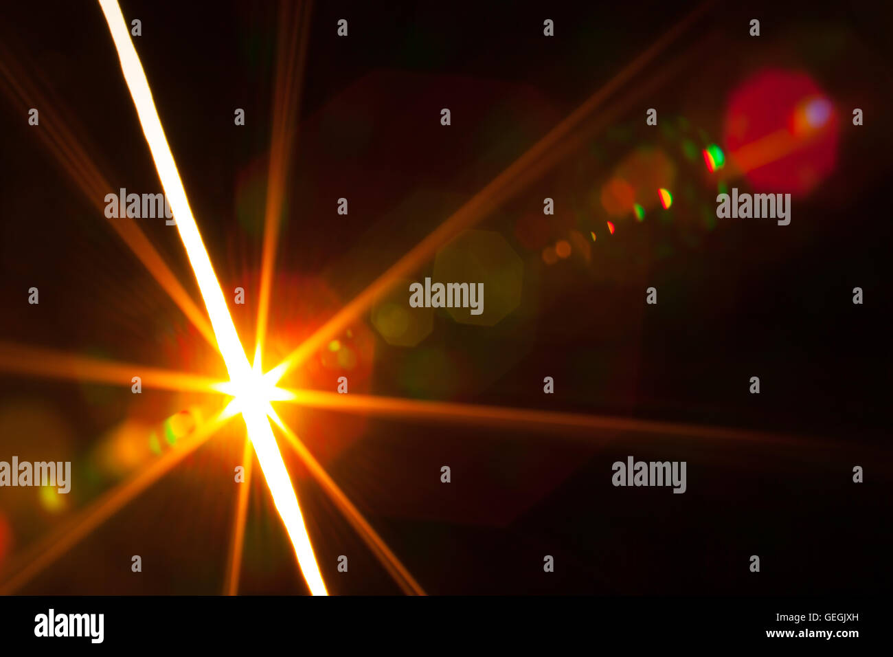 Vero e proprio obiettivo fotografico flare di una brillante luce attraverso una fessura Foto Stock