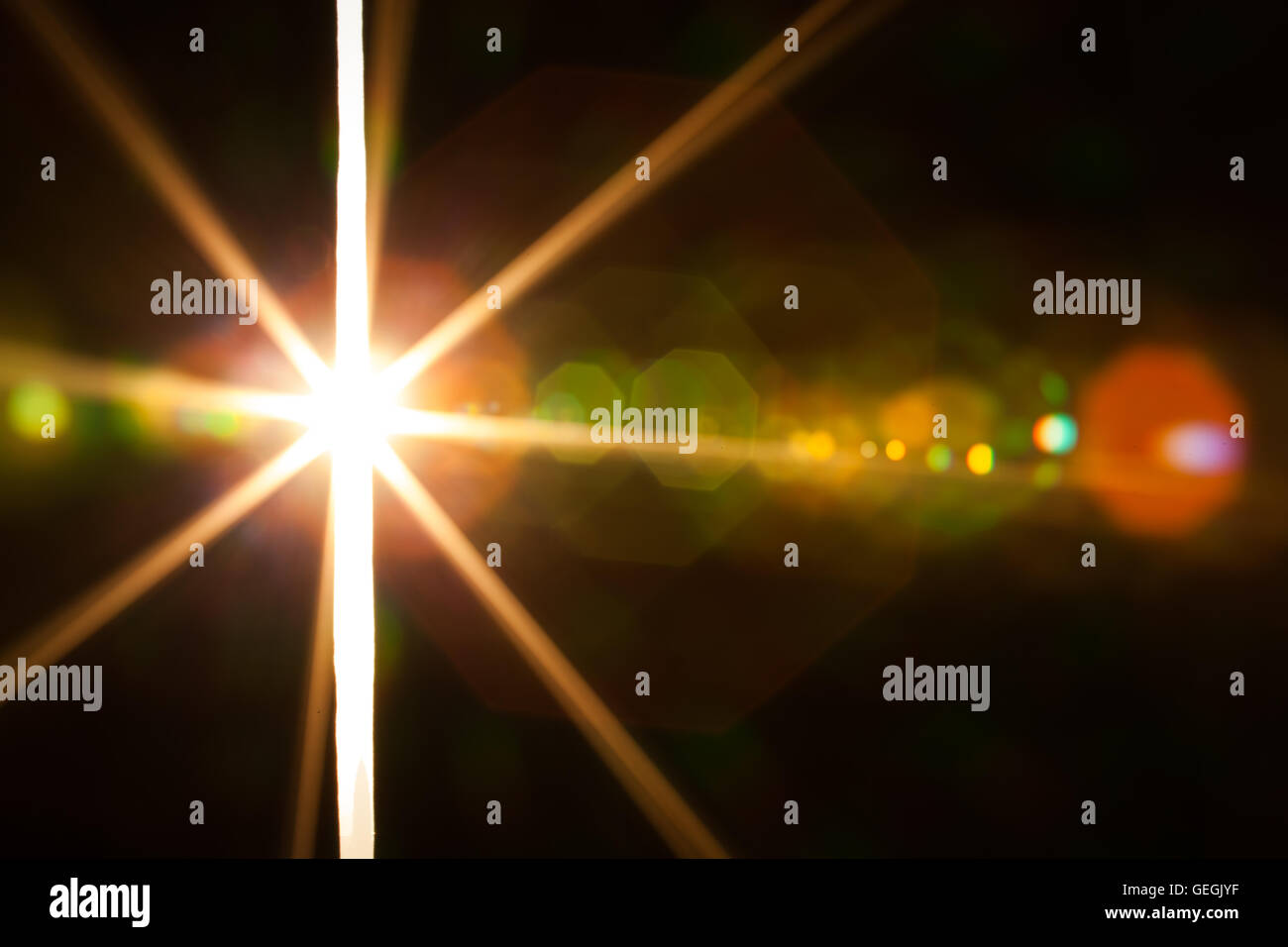 Vero e proprio obiettivo fotografico flare di una brillante luce attraverso una fessura Foto Stock