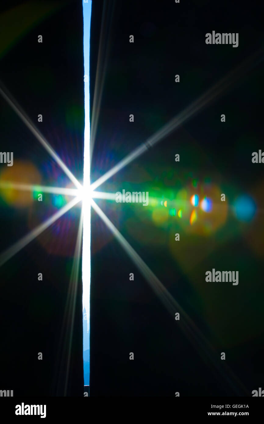 Vero e proprio obiettivo fotografico flare di una brillante luce attraverso una fessura Foto Stock