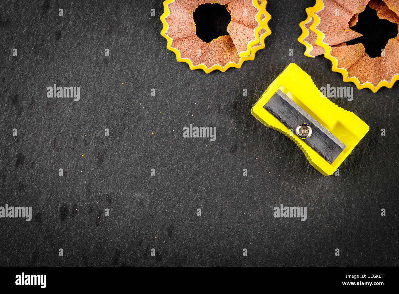 Giallo matita di trucioli e di giallo temperamatite su sfondo nero. L'immagine orizzontale. Foto Stock
