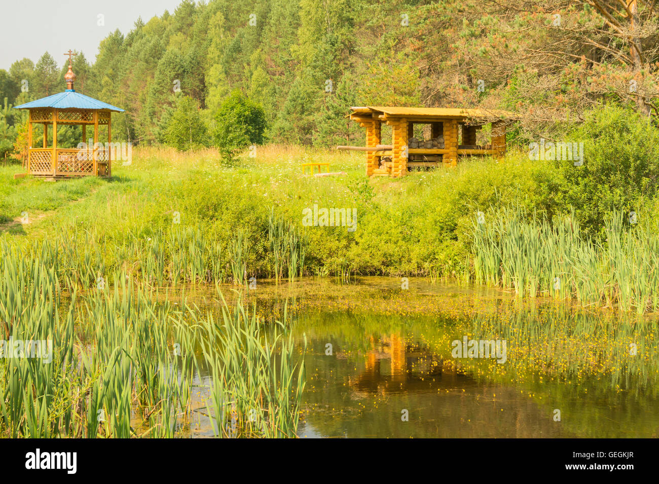 Summerhouse in legno sul bordo di una foresta in legno vicino al piccolo lago Foto Stock