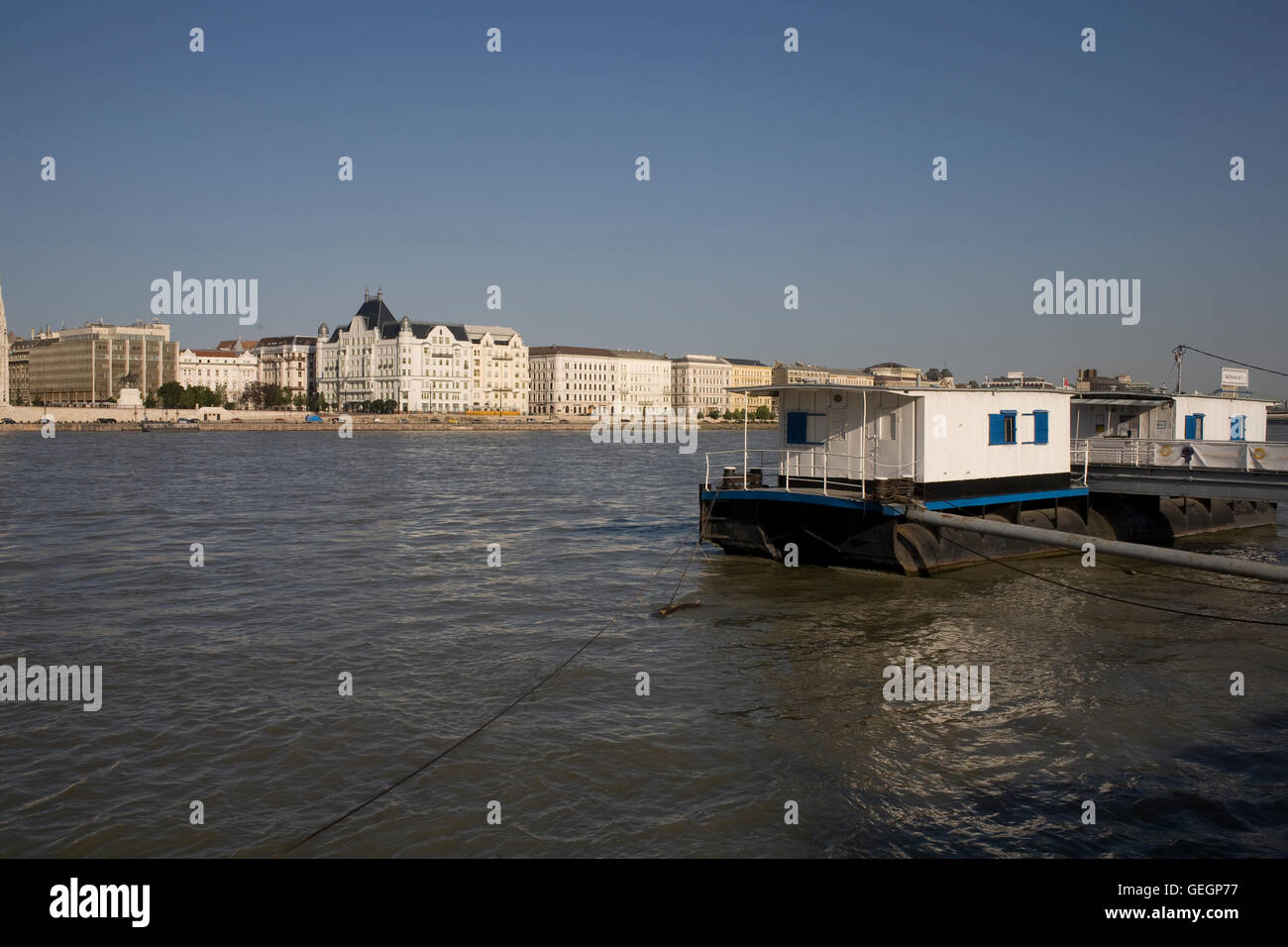 Chiatta ormeggiata presso Batthyany Ter con la parte meridionale di Antall Joszef quay attraverso il Danubio Foto Stock