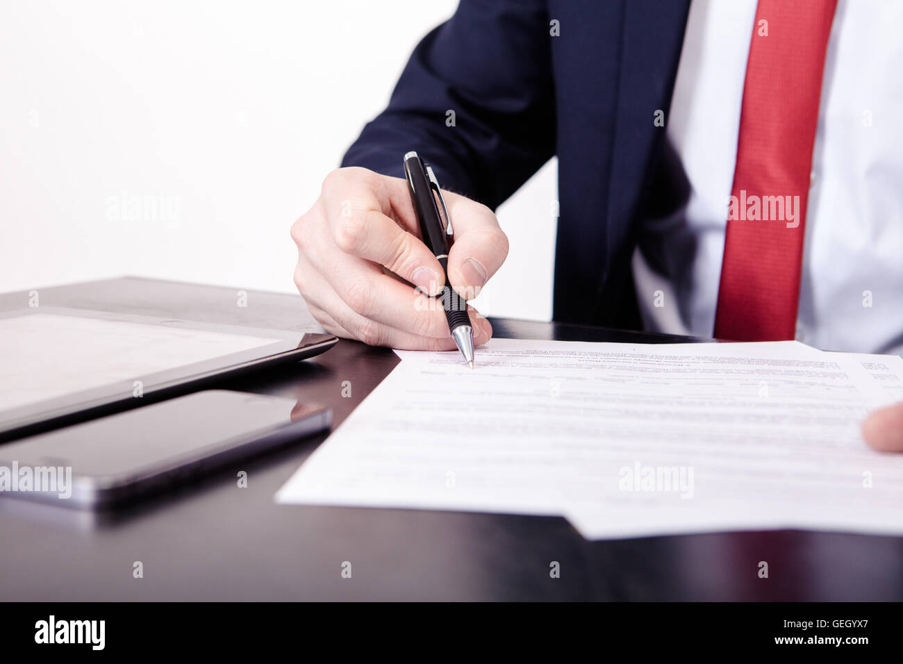 Riprese di direttore finanziario con le mani in mano firma contratto di business alla scrivania nel suo ufficio. Foto Stock