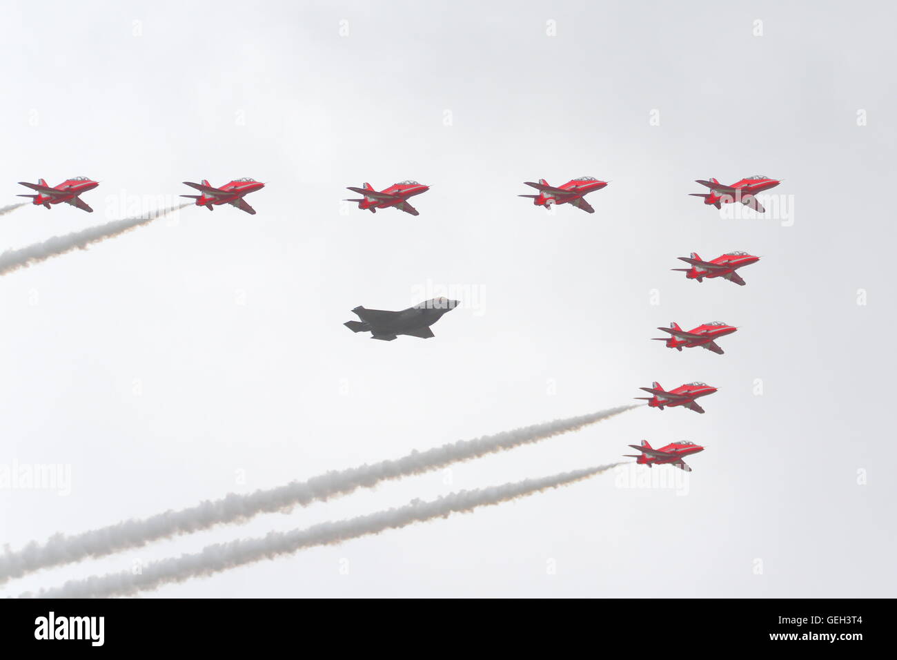 Flypast di Lockheed Martin F35 accompagnato da frecce rosse a Farnborough Airshow Internazionale 2016, REGNO UNITO Foto Stock