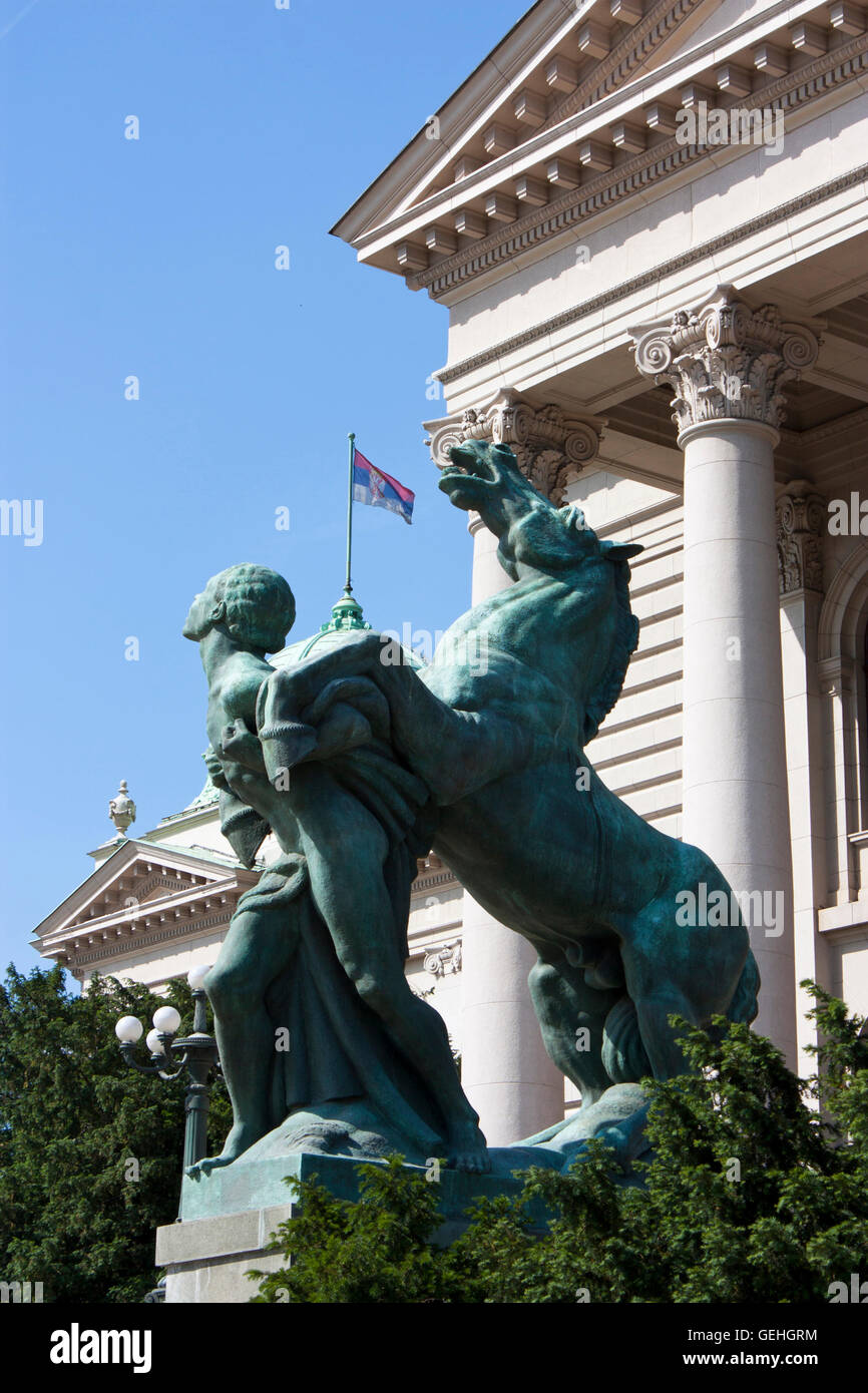 Statua in bronzo di fronte all'entrata dell'Assemblea nazionale della Repubblica di Serbia, Belgrado, con il serbo bandiera nazionale nella parte posteriore Foto Stock