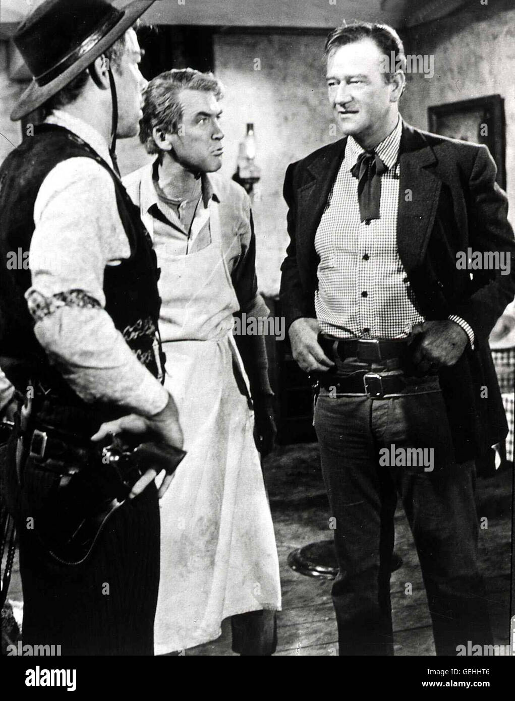 Lee Marvin, James Stewart, John Wayne Der junge Anwalt Ransom Stoddard (James Stewart,m) verdient sich seinen Lebensunterhalt als Kellner. Als er wieder einmal von Liberty Valence (Lee Marvin,l) schickaniert wird, weist Tom Doniphon (John Wayne) diesen Foto Stock