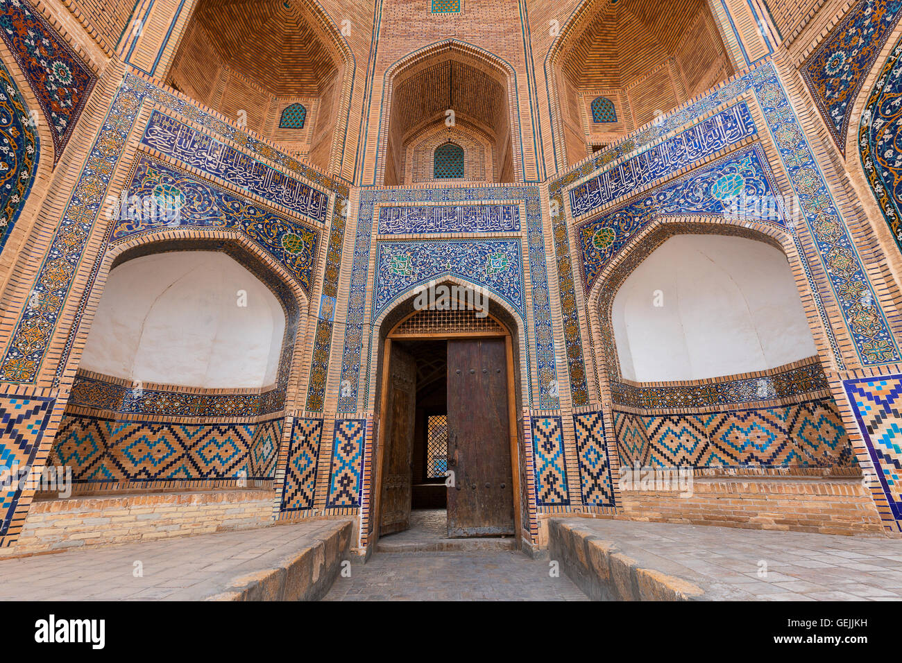 Muro ad arco e porta di poi Kalon Madrasa a Buhara, Uzbekistan Foto Stock