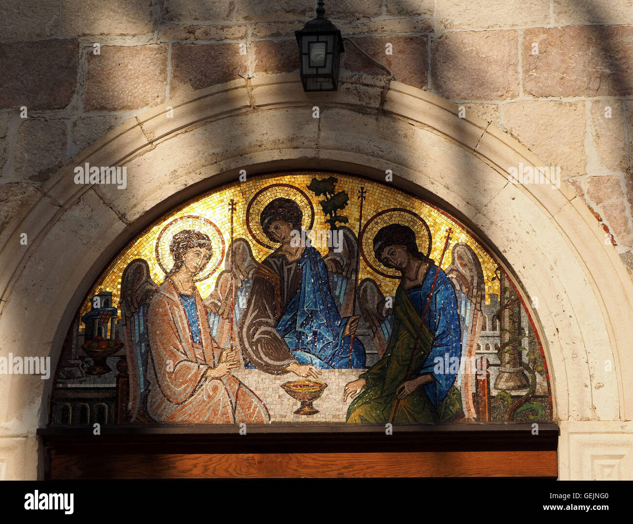Mosaico icone nel pannello arcuato sopra Chiesa Ortodossa porta con sopra la lanterna, Budva Old Town Montenegro nella luce della sera Foto Stock