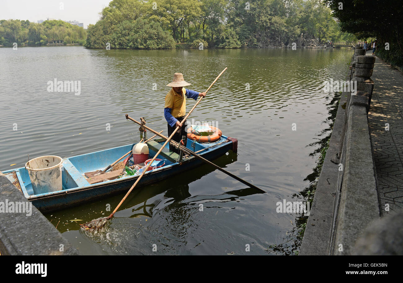 Nanchang, cinese della provincia di Jiangxi. 26 Luglio, 2016. Quande Xiong raccoglie la spazzatura sul lago Donghu di Bayi Park di Nanchang, Cina orientale della provincia di Jiangxi, 26 luglio 2016. Il 66-anno-vecchio Xiong Quande ha lavorato presso il parco come un lavoratore di igiene per un periodo di dodici anni a. La gente lo ha chiamato "estetista' del Lago Donghu. © Xiang Wan/Xinhua/Alamy Live News Foto Stock