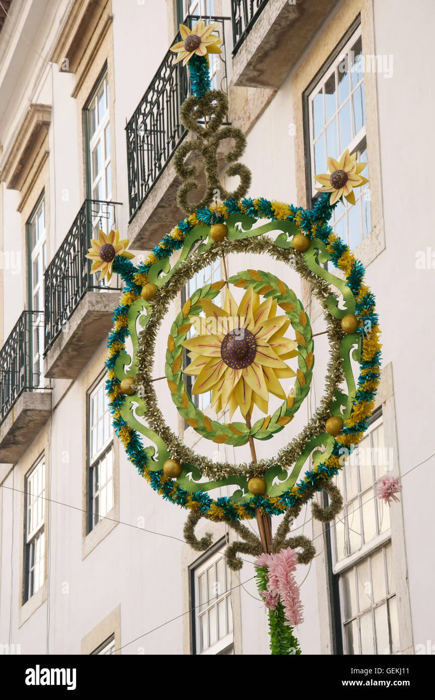Un girasole motivo al centro di una Pasqua decorazione fatta di tinsel, sospese al di sopra di un vicolo in Alfama, Lisbona, Portogallo. Foto Stock