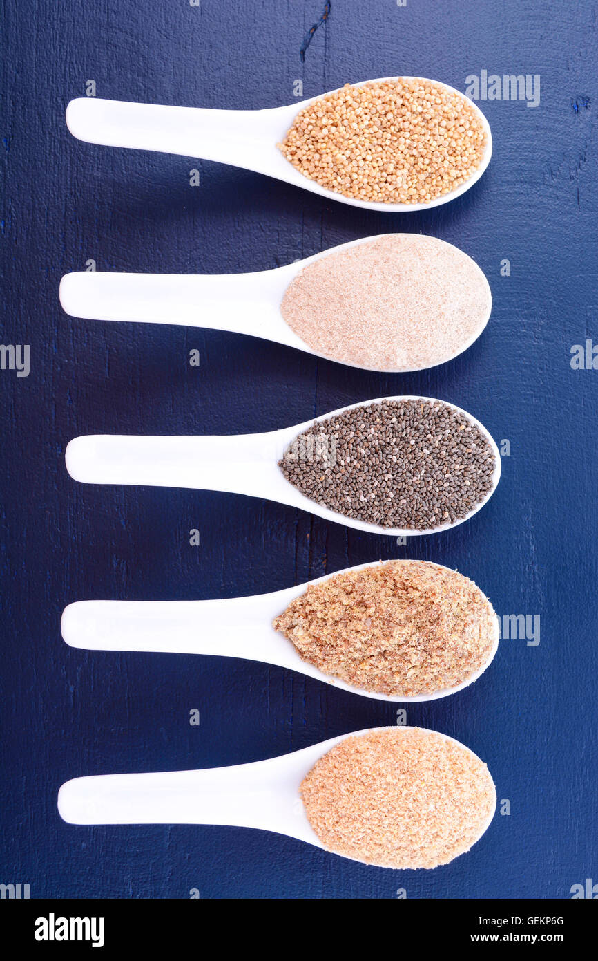 Granuli compresi, grano bianco quinoa, psillio lolla di polvere nera, Chia, il germe di grano e la massa LSA mix, in bianco misurino Foto Stock