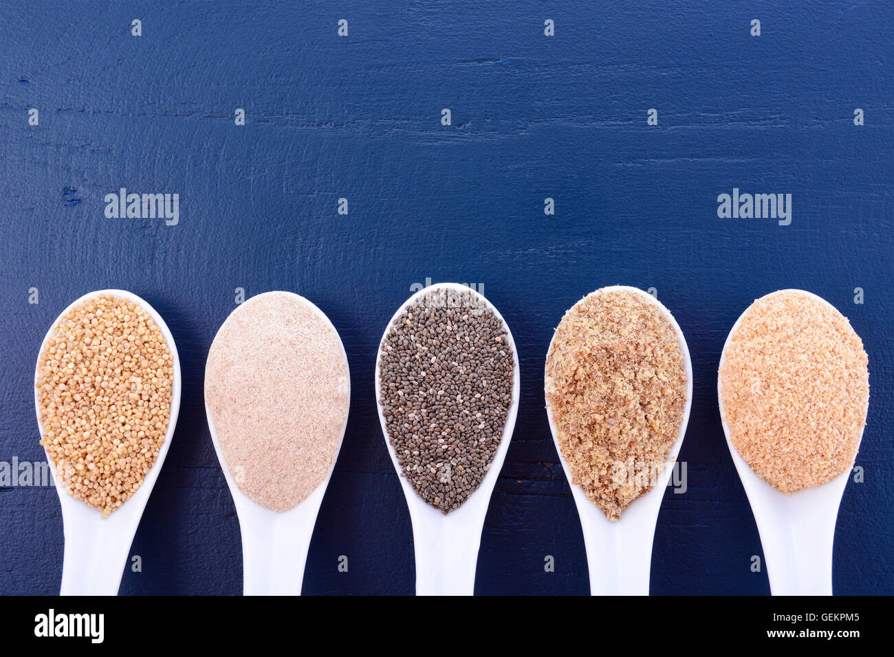 Granuli compresi, grano bianco quinoa, psillio lolla di polvere nera, Chia, il germe di grano e la massa LSA mix, sul blu scuro a grana di legno Foto Stock