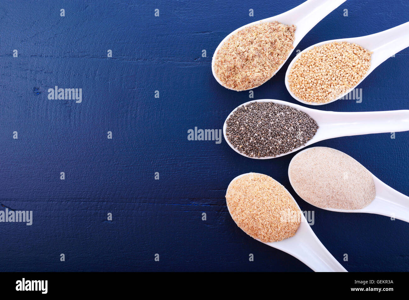 Granuli compresi, grano bianco quinoa, psillio lolla di polvere nera, Chia, il germe di grano e la massa LSA mix, sul blu scuro a grana di legno Foto Stock