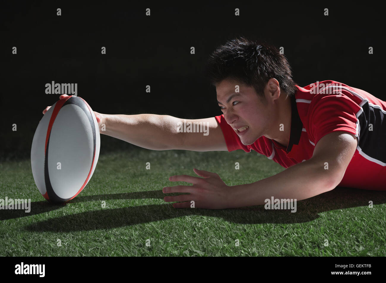 Ritratto di giapponese giocatore di rugby immersioni il cliente a provare Foto Stock