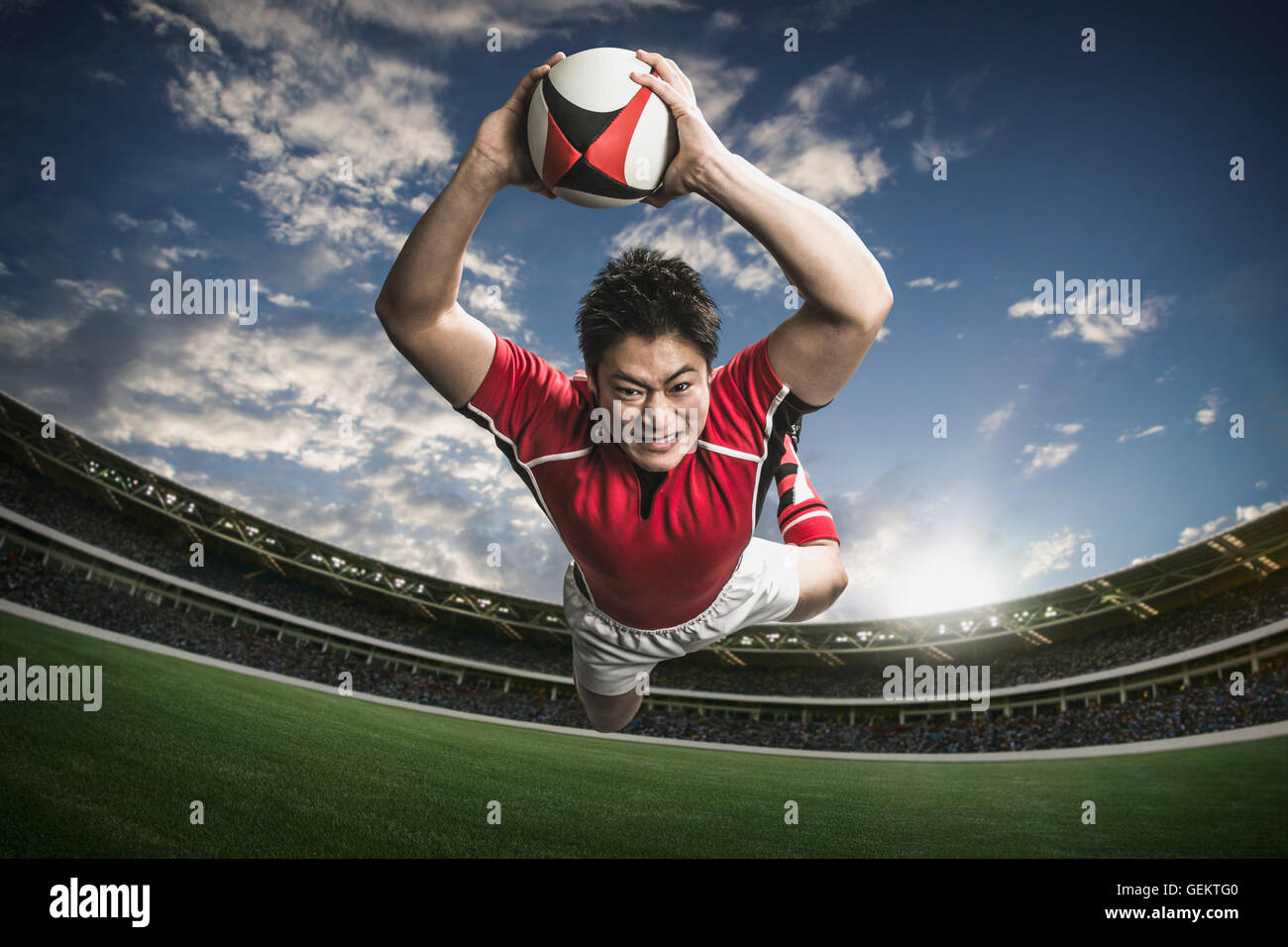 Ritratto di giapponese giocatore di rugby immersioni il cliente a provare Foto Stock