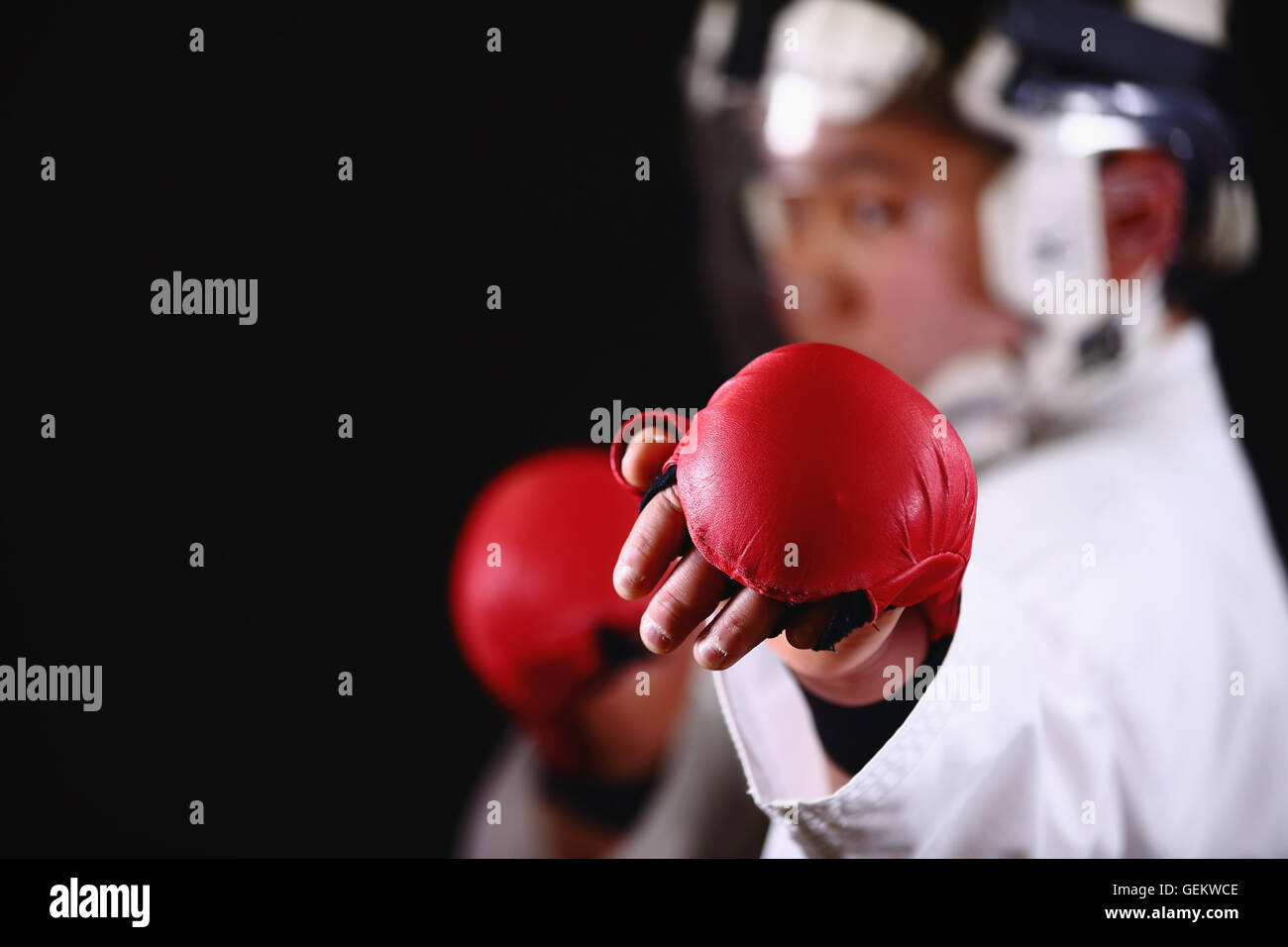 Ragazzo giapponese nel karate uniforme su sfondo nero Foto Stock