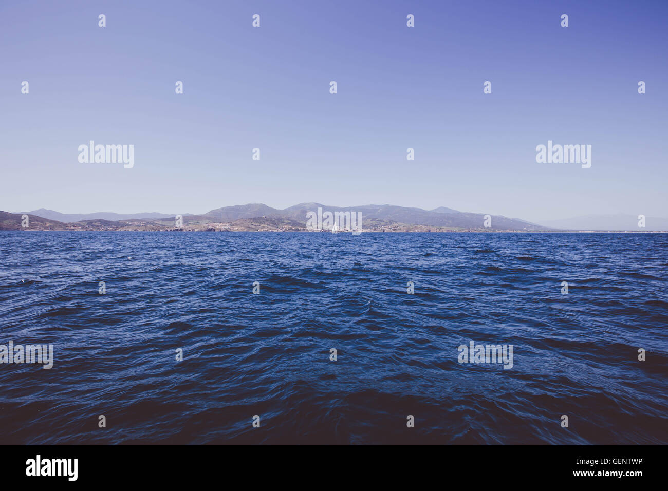 Orizzonte sul mare con una barca a vela in scena la linea costiera della francese mare Mediterranea. Foto Stock