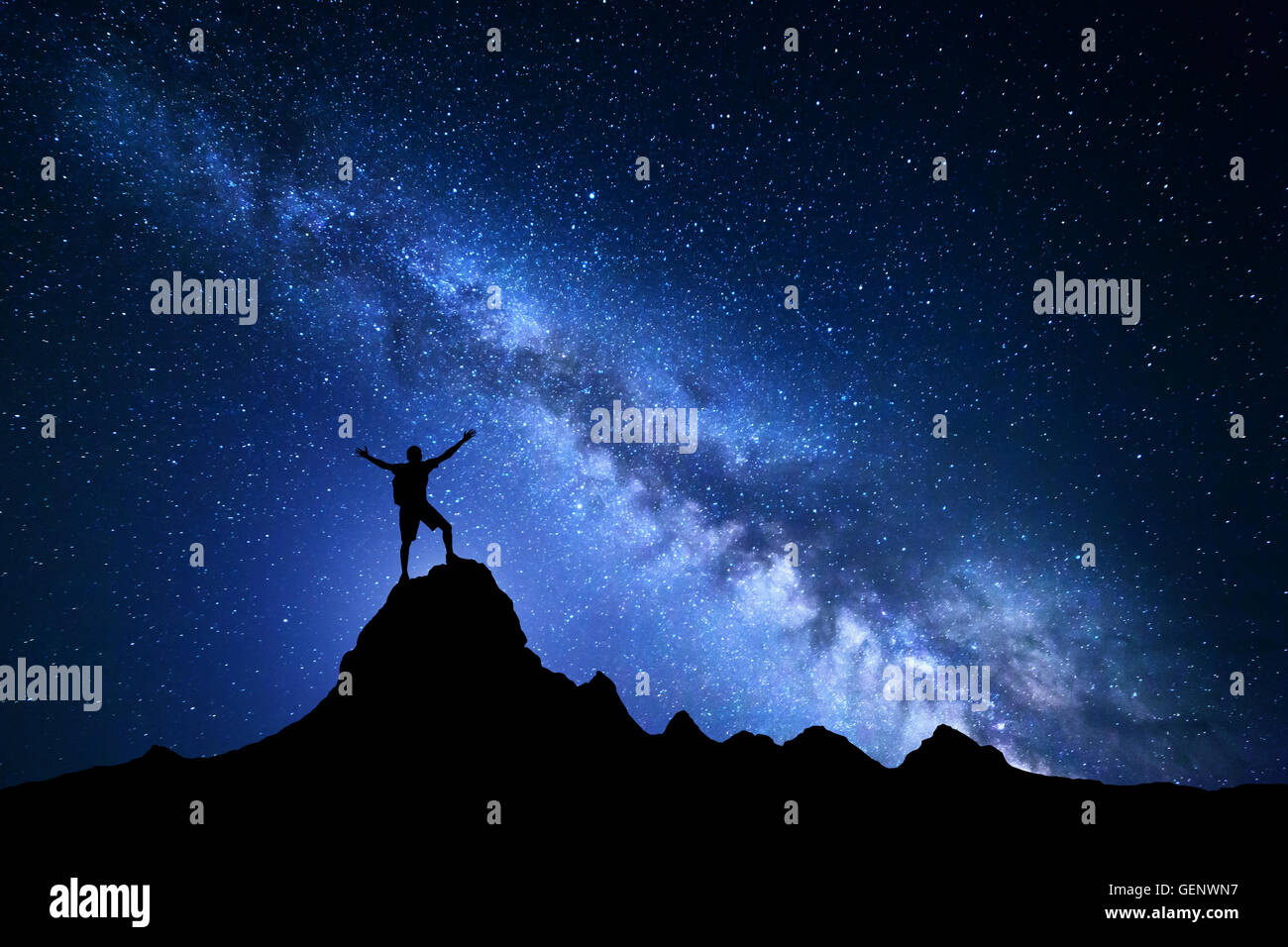 Paesaggio con Via Lattea. Notte Blu cielo con le stelle e la silhouette di un felice scalatore con zaino e sollevate le armi sul per Foto Stock