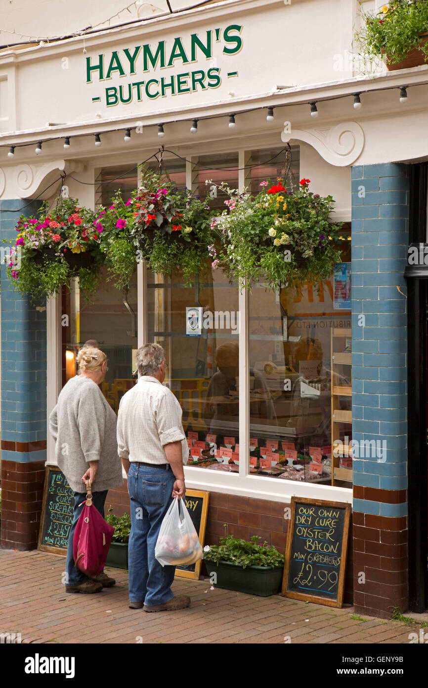 Regno Unito, Inghilterra, Devon, Sidmouth, Church Street, Hayman's macelleria, nei cestini appesi al di sopra della finestra Foto Stock