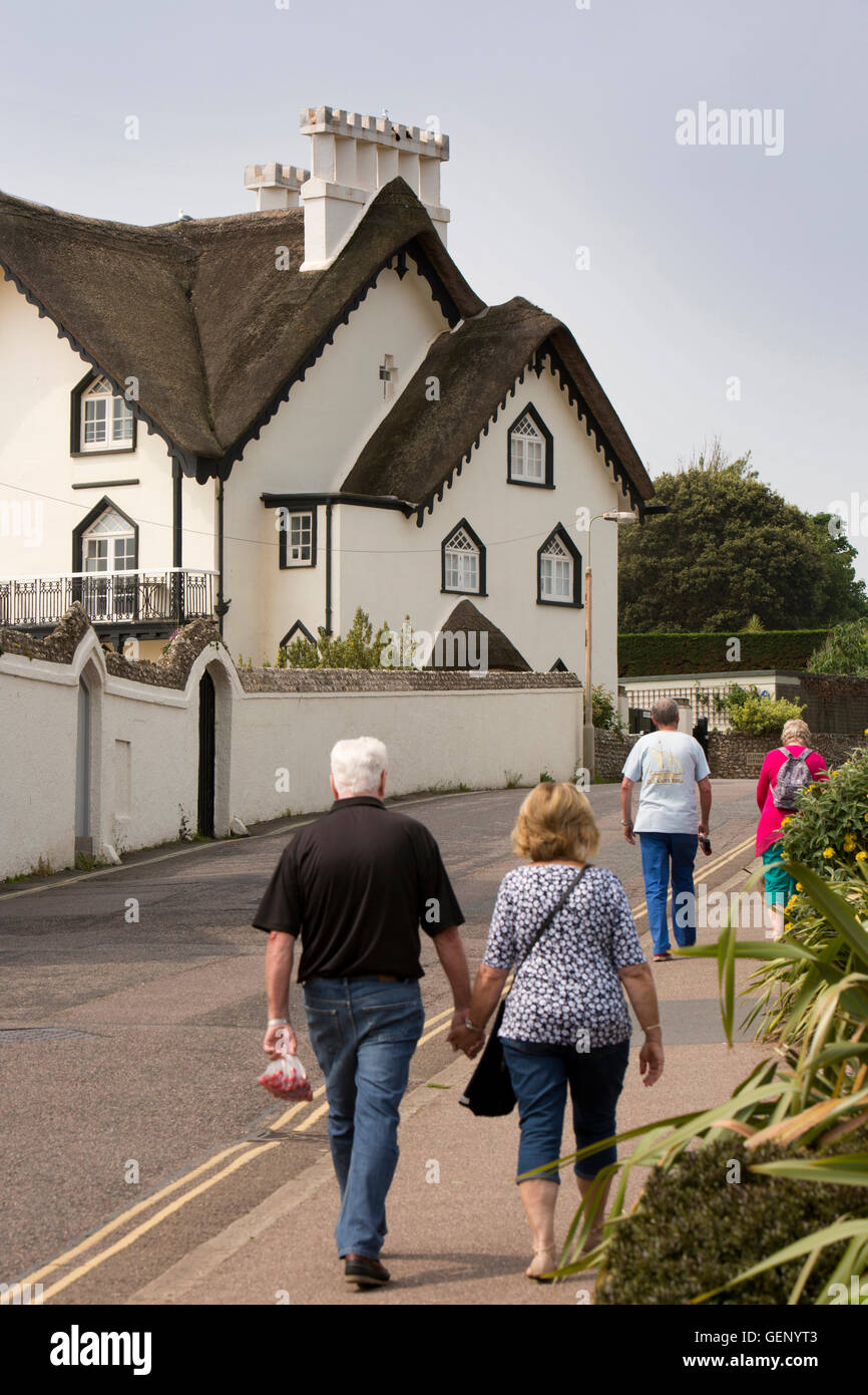 Regno Unito, Inghilterra, Devon, Sidmouth, Picco Hill Road, gente camminare passato Clifton cottage con il tetto di paglia casa fronte mare Foto Stock