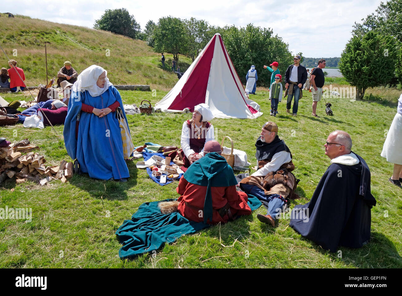 Persone vestite con abiti medievali hanno pic nic sul prato. Rievocazione, Halland . Svezia Foto Stock