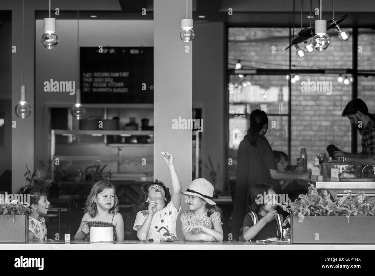 I bambini godono di uno snack presso l'aria aperta cafe in Cambridge. Foto Stock