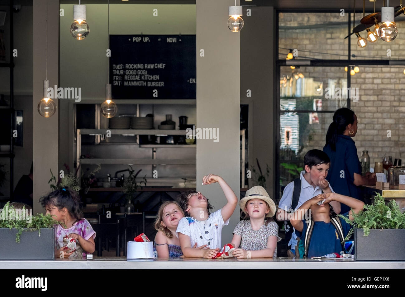 Un gruppo di bambini i bambini godono di uno snack presso l'aria aperta cafe. Foto Stock