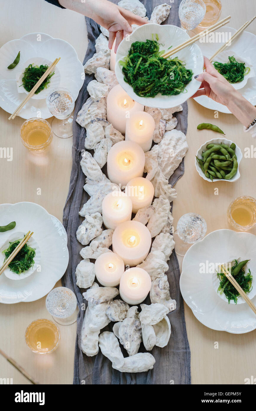 Vista aerea di quattro persone che condividono un pasto, piastre di sushi e una tabella per una celebrazione del pasto. Foto Stock