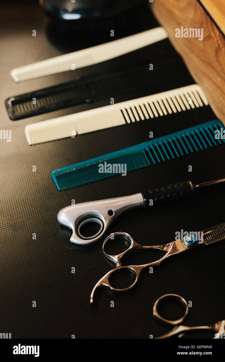 Una fila di pettini per capelli e capelli taglienti forbici da taglio. Foto Stock
