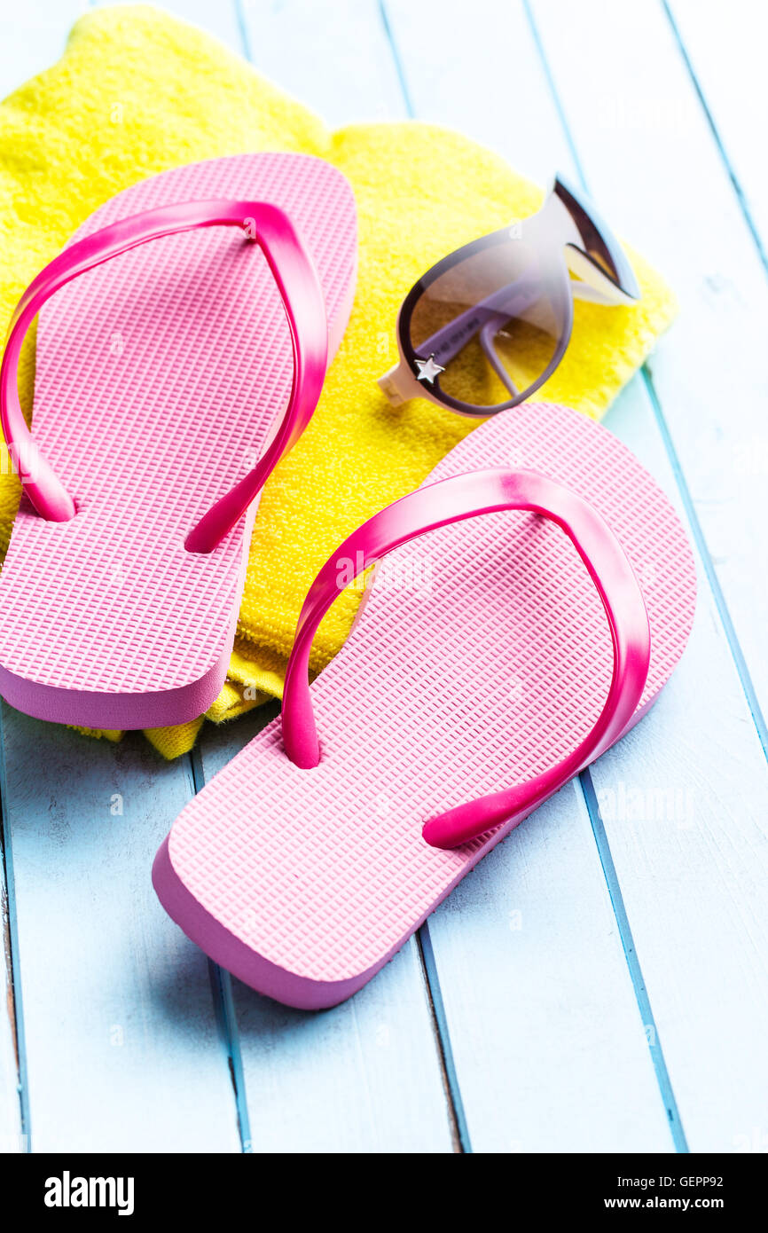 Rosa flip flop con asciugamano e occhiali da sole. Foto Stock