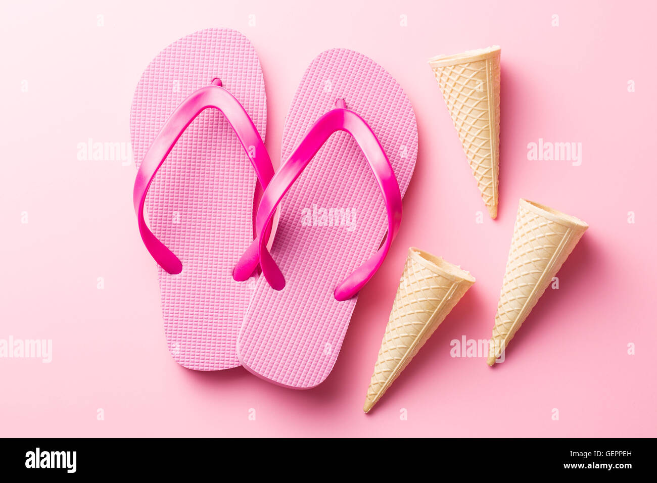 Il flip flop e coni su sfondo rosa. Foto Stock