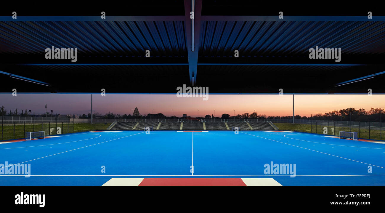 Panorama con campo di hockey su prato in Blu al tramonto. Eton Manor - Lee Valley Hockey e il Centro Tennis, Londra, Regno Unito. Architetto: Stanton Williams, 2014. Foto Stock