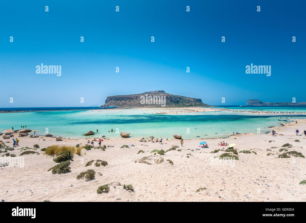 Laguna di Balos sull isola di Creta, Grecia. I turisti relax e bagno in acqua cristallina. La sabbia è rosa in alcune parti della spiaggia. Foto Stock