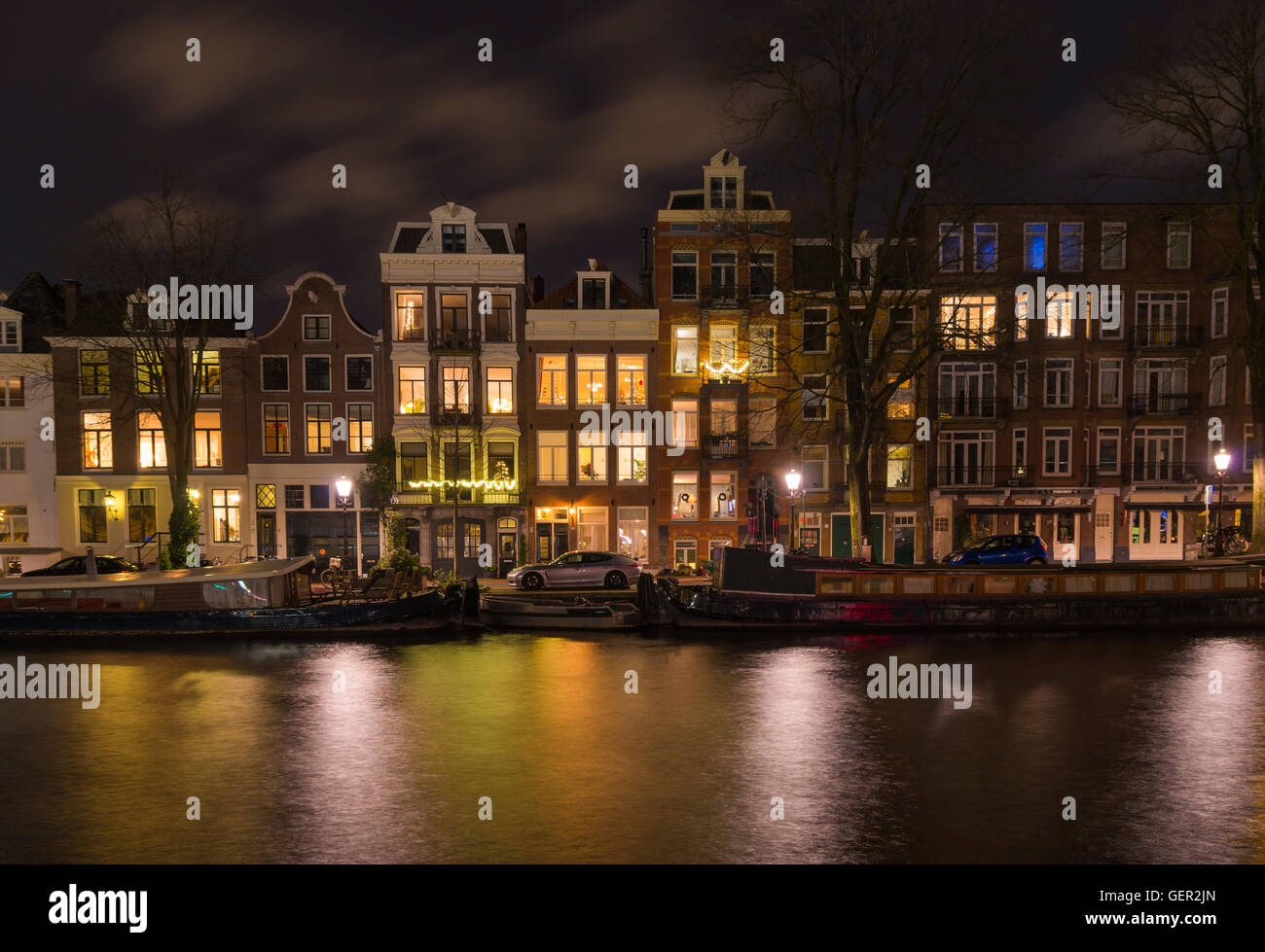 Vista notturna di alcune tradizionali case a capanna lungo un canale di amsterdam Foto Stock