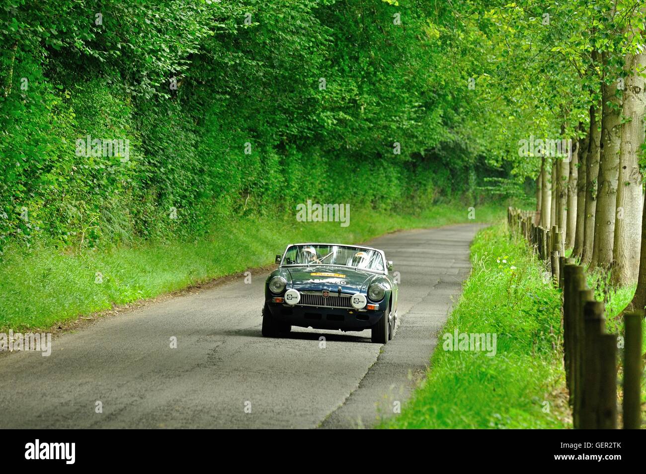MGB roadster guidato dalla coppia matura sul classico auto rally estivo nel sud dell'Inghilterra Foto Stock