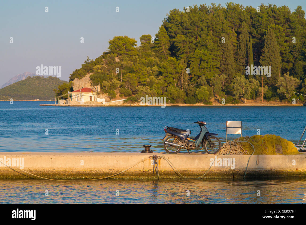 Un vecchio ciclomotore su un porto greco parete Foto Stock