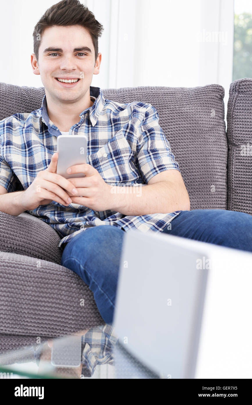 L'uomo streaming di musica dal telefono cellulare per altoparlante senza fili Foto Stock