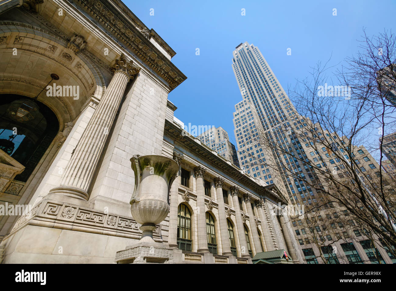 Ornamenti e dettagli architettonici sulla Biblioteca Pubblica di New York facciata con un grattacielo in background. Midtown, New York Foto Stock