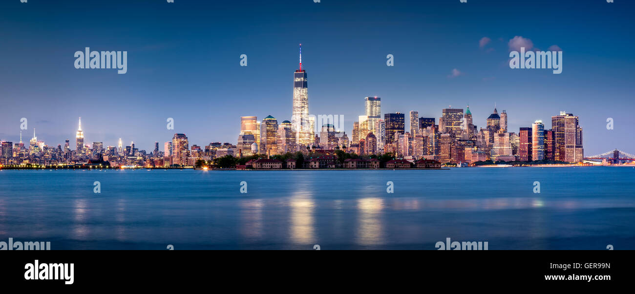Panoramica del Distretto Finanziario di Manhattan al crepuscolo con Ellis Island e il World Trade Center. La città di New York Foto Stock