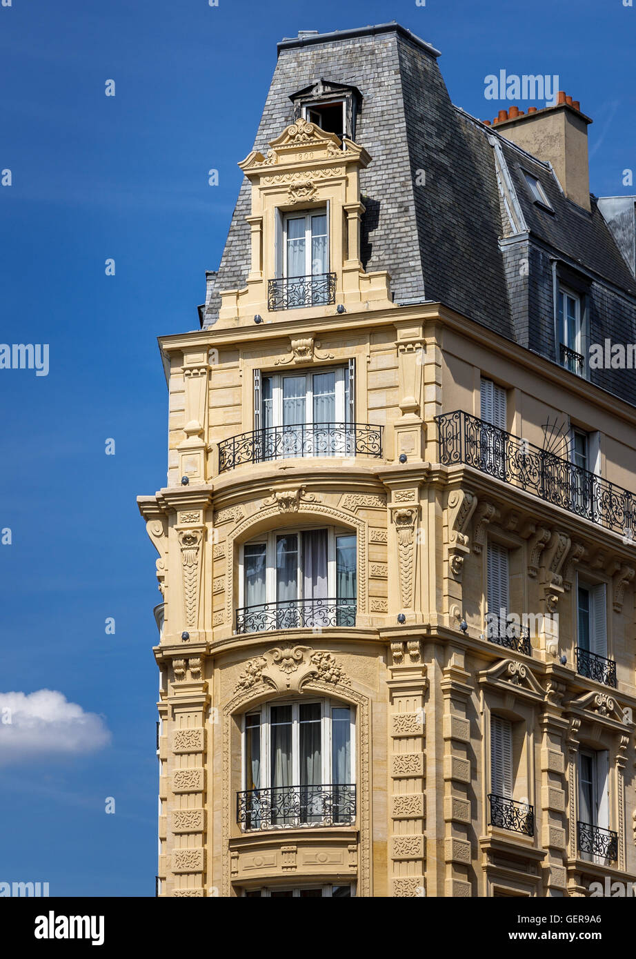 Edificio in stile haussmanniano, nel cuore di Parigi con lavori decorativi in pietra e balconi in ferro battuto e un ardesia tetto a mansarda. Francia Foto Stock