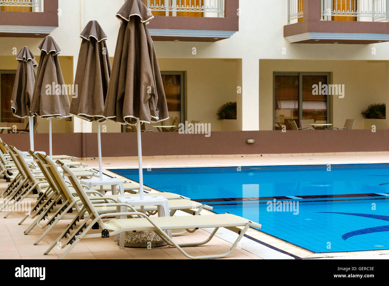 Svuotare i lettini e gli ombrelloni sono presso la piscina vuota senza i turisti nelle prime ore del mattino. Rilassarsi e prendere il sole in piscina, Creta Foto Stock