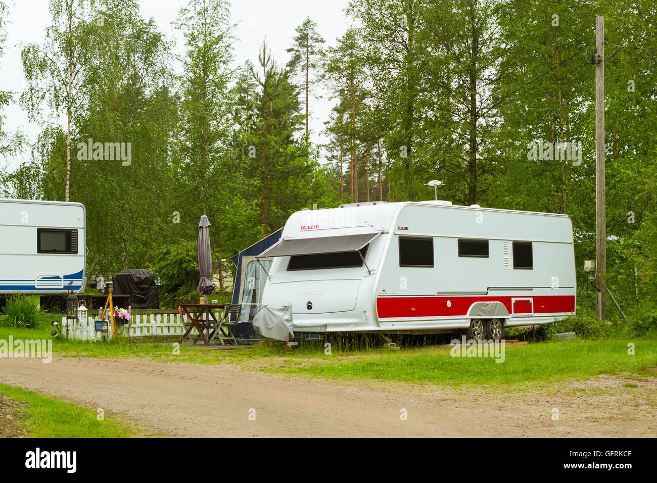 Estate di attività ricreative all'aperto, scandinavo vacanza in casa su ruote. Camping furgoni e tende parcheggiato su un verde prato in campeggio Foto Stock